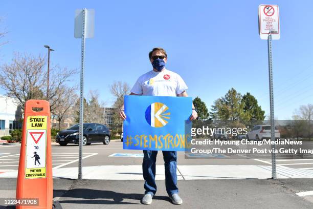 Parent of STEM School Highlands Ranch holds the sign at the parking of school. Students and parents car rally for one year memorial of STEM School...
