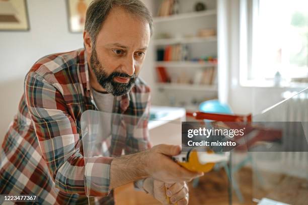 man caulking a glass partition - caulk gun stock pictures, royalty-free photos & images
