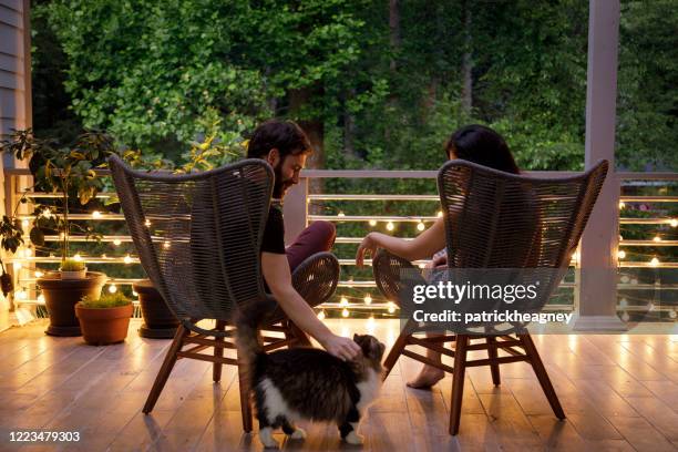 couple on patio in the evening - house dusk stock pictures, royalty-free photos & images