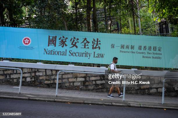 Pedestrians walks past a government-sponsored advertisement promoting a new national security law on June 30, 2020 in Hong Kong, China.