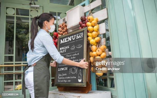 business owner reopening a restaurant while wearing a facemask - restaurant manager covid stock pictures, royalty-free photos & images