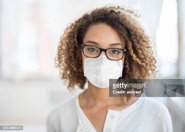 african american business woman wearing a facemask at the office to avoid covid-19 - businesswoman mask stock pictures, royalty-free photos & images