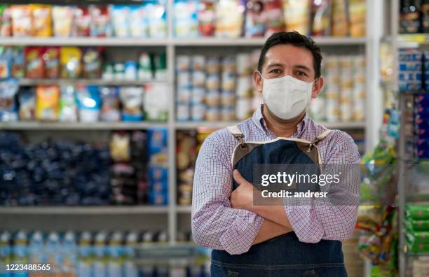 business owner working at a grocery store wearing a facemask - supermarket mask stock pictures, royalty-free photos & images