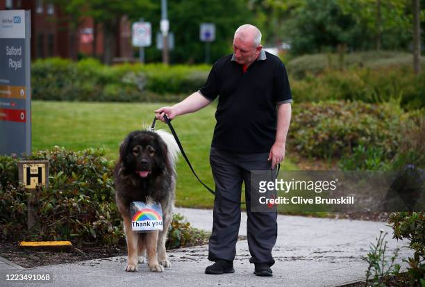 Member of the public shows off his dog who is wearing a sign reading 'Thank you' during the applause for key workers at Salford Royal Hospital on May...
