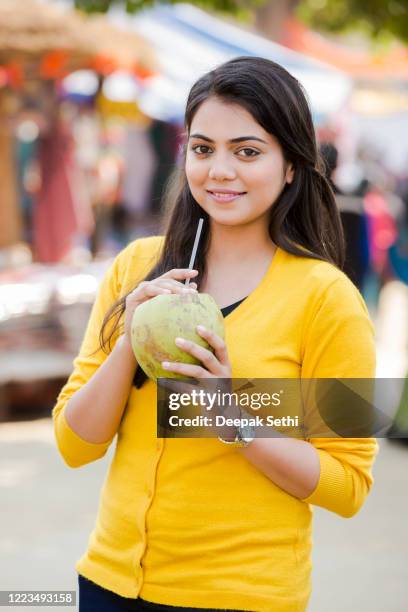 young girl drinking coconut water at street market stock photo - coconut water stock pictures, royalty-free photos & images