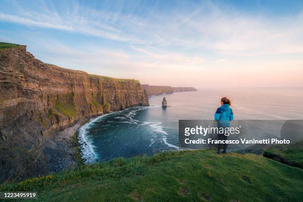 woman at the cliffs of moher, ireland. - cliffs of moher stock-fotos und bilder