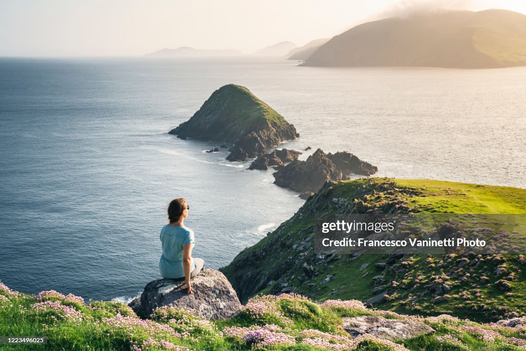 Woman at Dunmore Head gazing at the Devil Horns, Ireland.