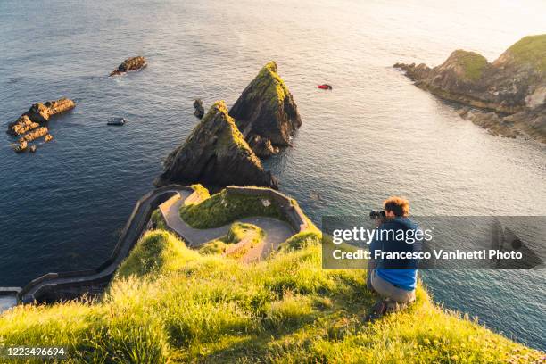 photographer at dunquin pier, ireland. - dingle bay stock pictures, royalty-free photos & images