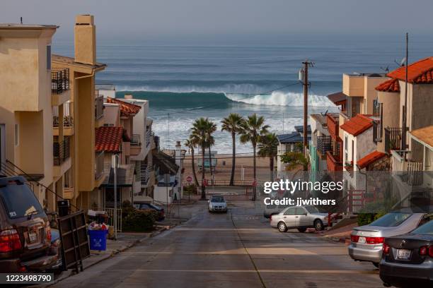 a large january winter surf swell with large waves at el porto beach, part of manhattan beach in los angeles county, california - el segundo ca stock pictures, royalty-free photos & images