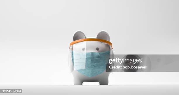 piggy bank wearing a surgical mask - covid finance stock pictures, royalty-free photos & images