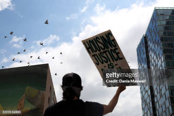 Protestor holds a sign up during a march with the L.A. Tenants Union to demand that the LAPD and the Apartment Association of Greater L.A. Abandon...