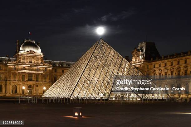 Super moon rises over the closed Louvre Museum and Louvre Pyramid as the lockdown continues due to the coronavirus outbreak on May 07, 2020 in Paris,...