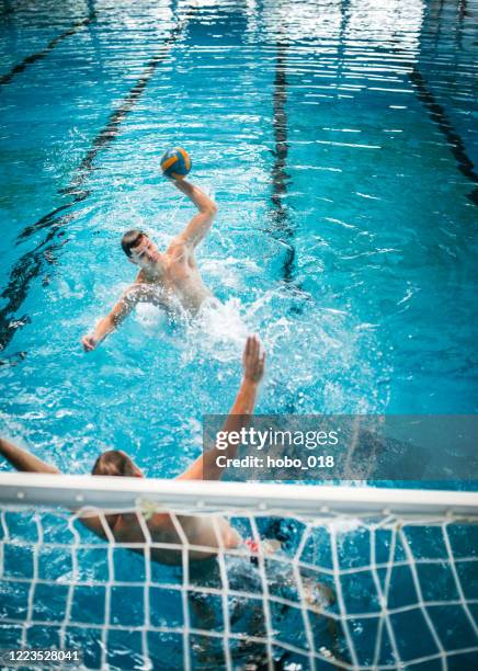vader en zoon die waterpolo bij zwembad beoefenen - waterpolo stockfoto's en -beelden
