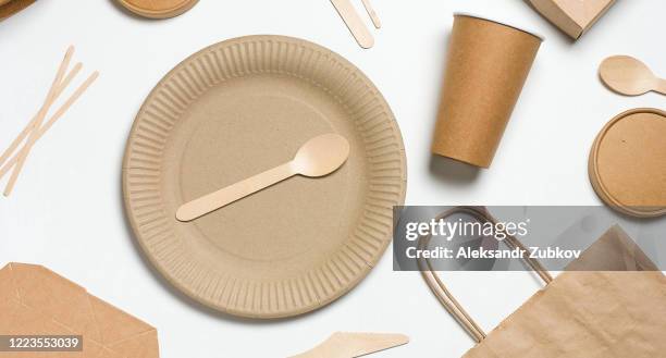 disposable tableware made of bamboo wood and paper on a white background. the photo is covered in graininess and noise. - a plate made of paper stock-fotos und bilder