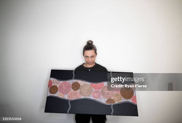 Australian Cricketer Ash Gardiner poses with one of her original paintings at her home on May 08, 2020 in Sydney, Australia. Gardiner tried...