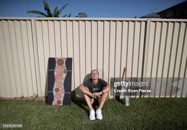 Australian Cricketer Ash Gardiner poses with two of her original paintings at her home on May 08, 2020 in Sydney, Australia. Gardiner tried...