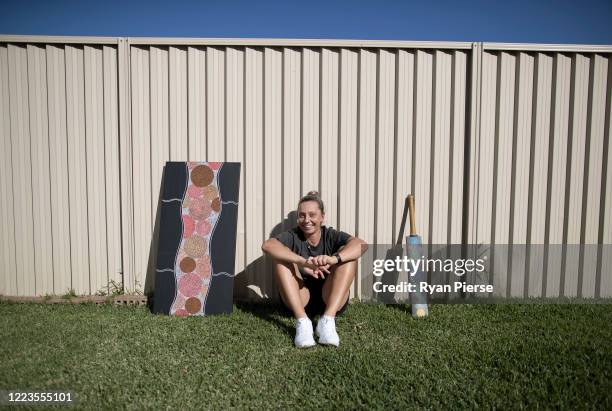 Australian Cricketer Ash Gardiner poses with two of her original paintings at her home on May 08, 2020 in Sydney, Australia. Gardiner tried...