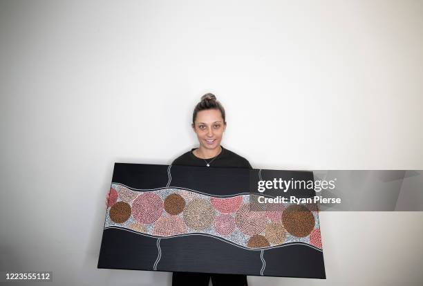 Australian Cricketer Ash Gardiner poses with one of her original paintings at her home on May 08, 2020 in Sydney, Australia. Gardiner tried...