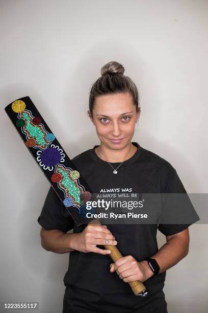 Australian Cricketer Ash Gardiner poses with one of her original paintings at her home on May 08, 2020 in Sydney, Australia. Gardiner tried...