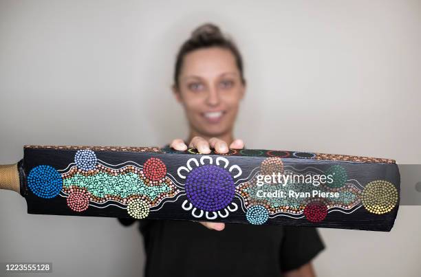 Australian Cricketer Ash Gardiner poses with one of her original paintings at her home on May 08, 2020 in Sydney, Australia. Gardiner tried...