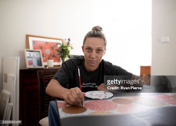 Australian Cricketer Ash Gardiner poses with one of her original paintings at her home on May 08, 2020 in Sydney, Australia. Gardiner tried...