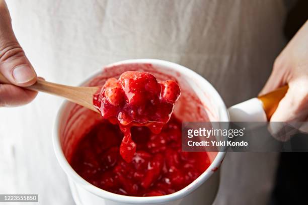 scoop the strawberry jam in the pan with a spoon - strawberry jam stock pictures, royalty-free photos & images