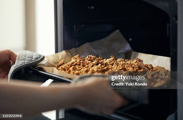 take the homemade granola out of the oven. - baking sheet 個照片及圖片檔