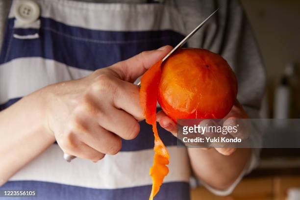 peel the persimmon. - 柿 ストックフォトと画像