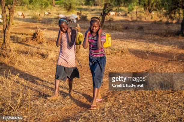 african children carrying water from the well, kenya, east africa - carrying water stock pictures, royalty-free photos & images