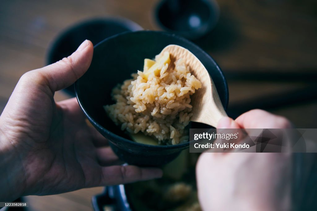 The hand that is serving the rice with the bamboo shoots.