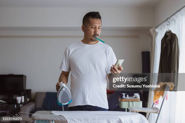 household husband ironing a shirt - housework ストックフォトと画像