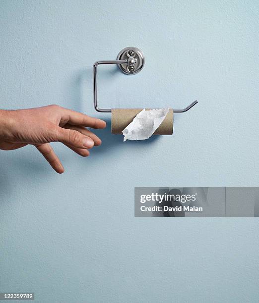 hand reaching for empty toilet paper roll. - reaching the end stock pictures, royalty-free photos & images