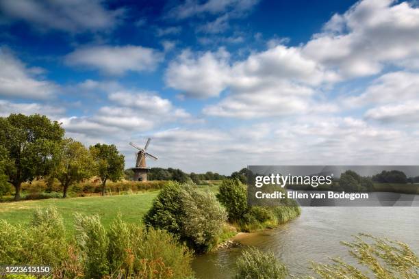 dutch landscape with view on windmill and river in summer - cumulus cloud stock pictures, royalty-free photos & images