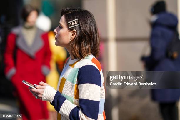Guest wears a Dior hair brooch, a colored checked wool pullover, earrings, outside Brock Collection, during New York Fashion Week Fall Winter 2020,...