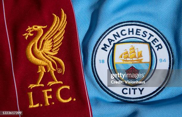 The Liverpool and Manchester City club crests on their first team home shirts displayed on May 5, 2020 in Manchester, England