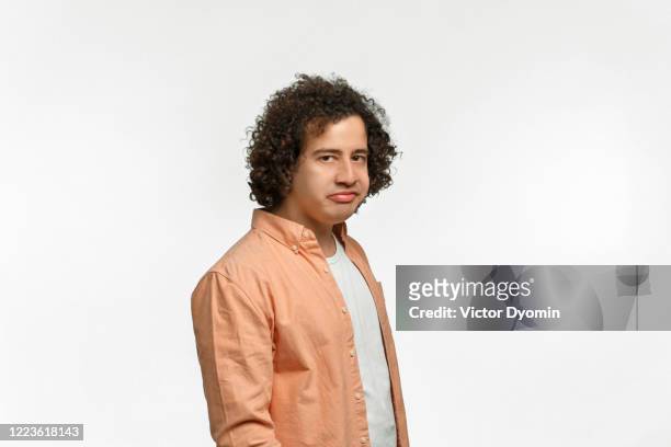 emotional portrait of a curly guy with brown hair - sneering stock pictures, royalty-free photos & images