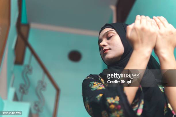 beautiful muslim woman is praying at home. ramadan namaz time. - namaz stock pictures, royalty-free photos & images