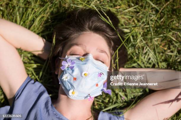 nap under flowered mask (top point of view), montargis, france. - coronavirus france stock-fotos und bilder