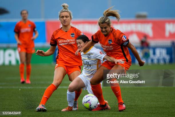 Diana Matheson of Utah Royals FC drives between Kristie Mewis and Kathrine Stengel of Houston Dash during a game in the first round of the NWSL...