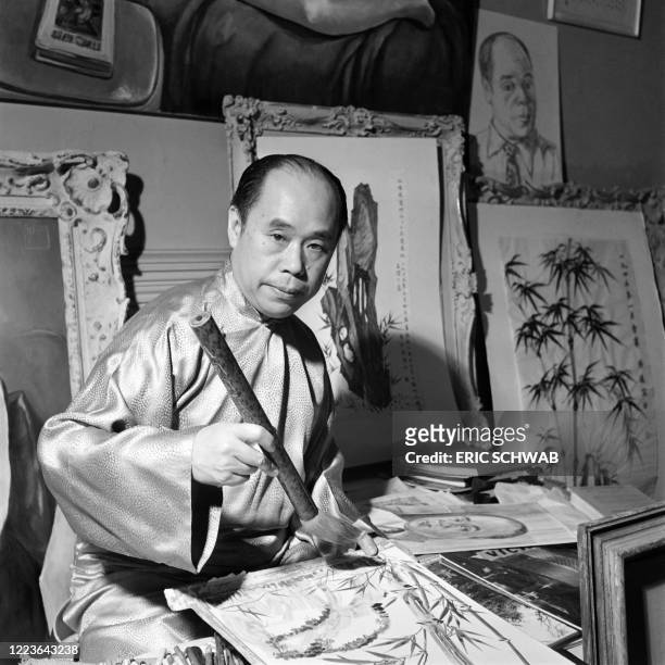 Chinese painter Wang Chi-Yuan, exiled in the United States since 1941, poses while painting with his bamboo brushes, in January 1947 in Chinatown,...