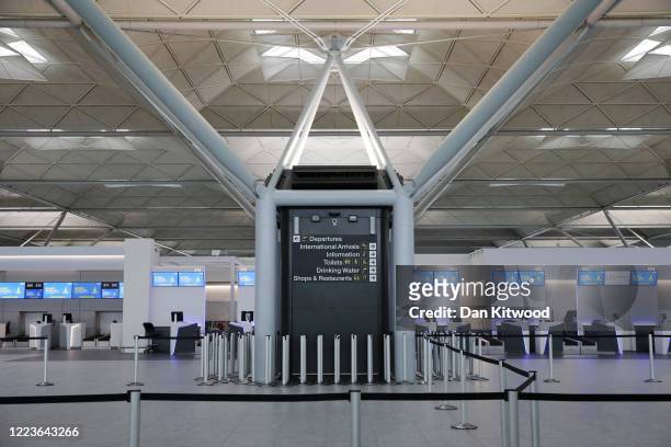 An empty check-in desk for Ryanair at Stansted Airport on June 30, 2020 in Stansted, United Kingdom. Passengers travelling between the UK and some...