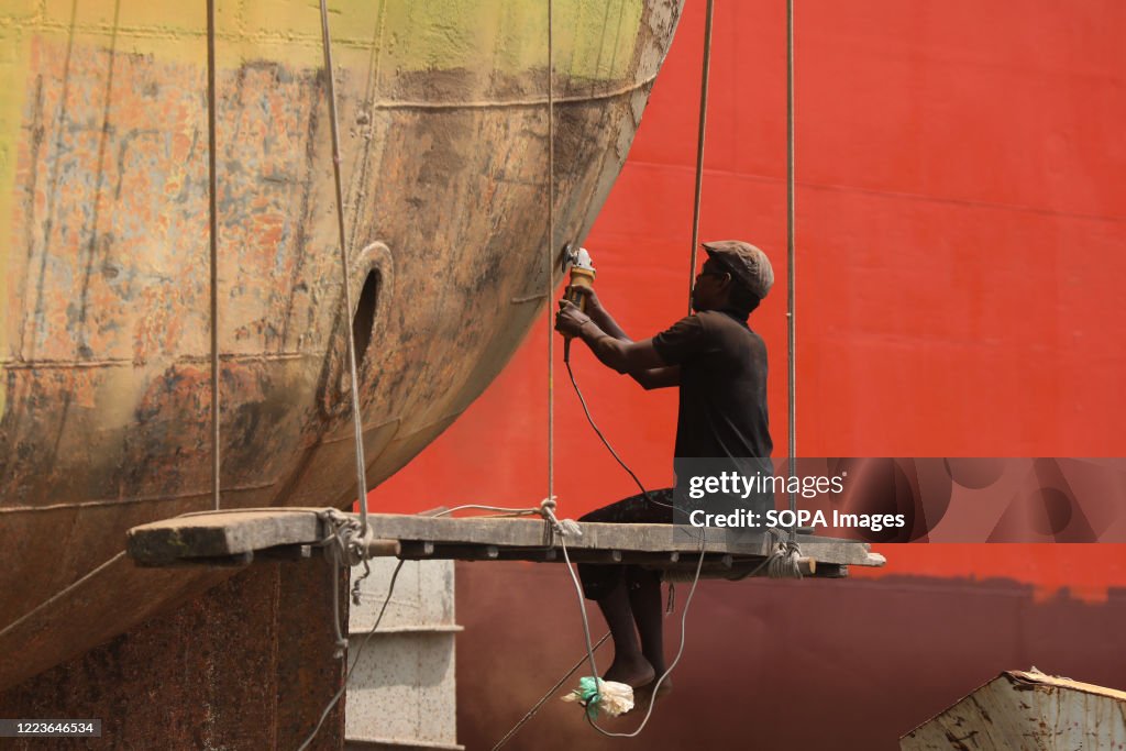 A labourer working on a ship at a breaking yard at...