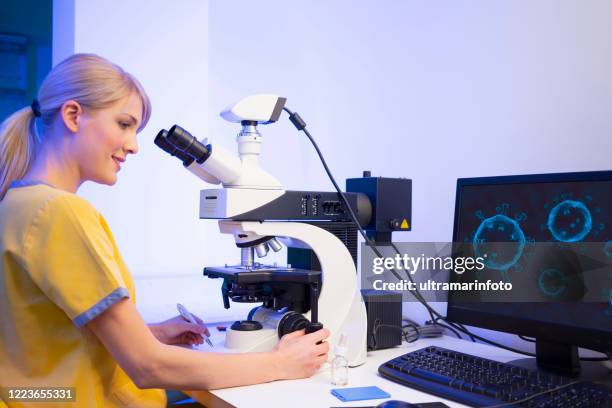 vrouwelijke arts in medisch laboratorium ontwikkeling van nieuwe vaccins coronavirus covid-19. medische test in het lab. wetenschapper in laboratorium die met medische steekproeven werkt gebruikend moderne elektronenmicroscoop. medische onderzoeksapparatuu - elektronenmicroscopisch-beeld stockfoto's en -beelden