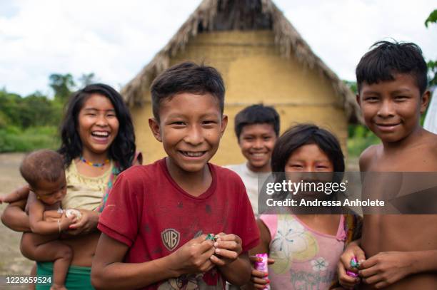 Yanomami children smile in front of their house at the Auaris on June 30, 2020 in Roraima, Brazil. The Yanomamis live in regions of difficult access...