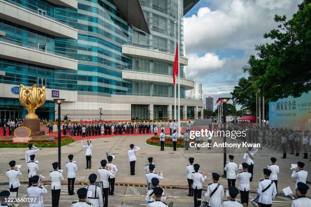 The flags of China and the Hong Kong Special Administrative Region fly as a Hong Kong Police Guard of Honour and police officers march following a...