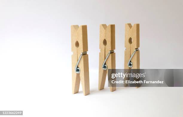 three clothespins on white background - clothes peg isolated stock pictures, royalty-free photos & images