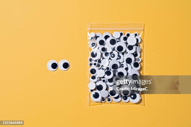 googly eyes standing out from the crowd - wackelaugen stock-fotos und bilder