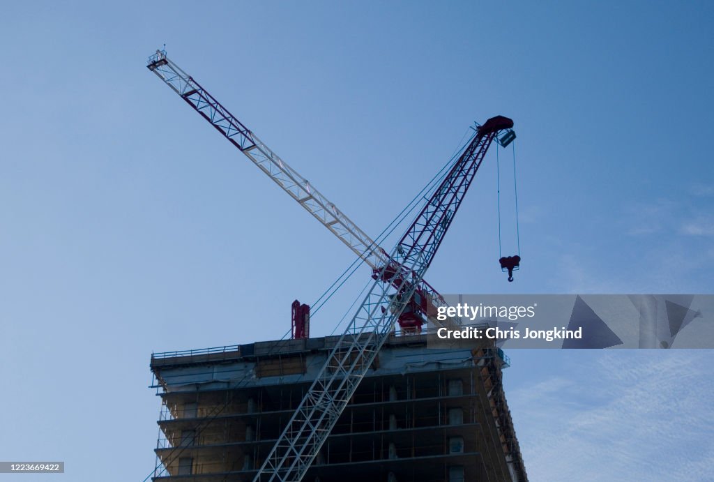 Two Cranes at Work on a Skyscraper Construction Site