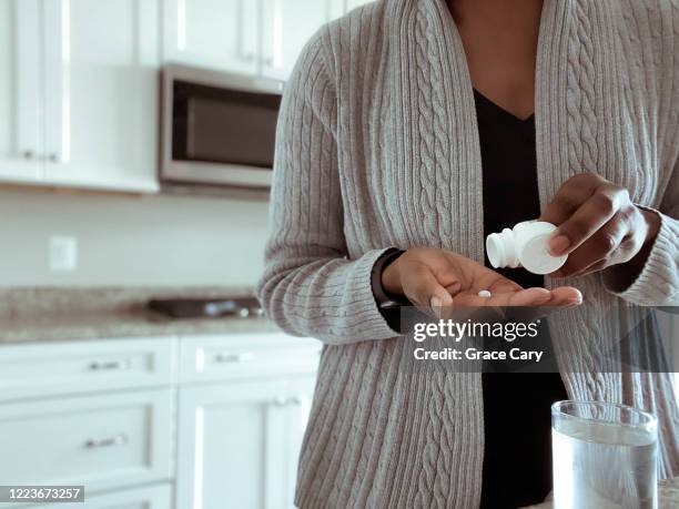 woman takes medication - aspirina foto e immagini stock