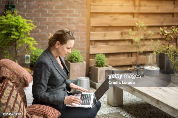 smart brunett professionell kvinna som arbetar från trädgården hemma - garden office bildbanksfoton och bilder